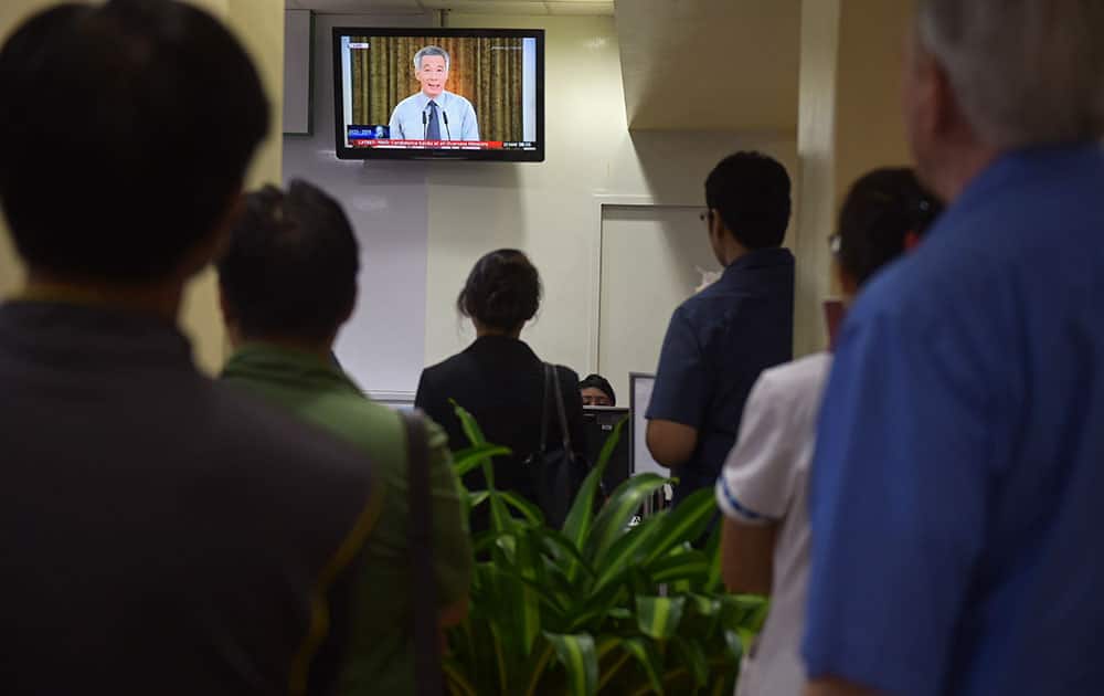 A live broadcast by Singapore Prime Minister Lee Hsien Loong on the death of his father is watched in a reception area at a hospital where Singapore's founding father Lee Kuan Yew passed away, on Monday, March 23, 2015 in Singapore.