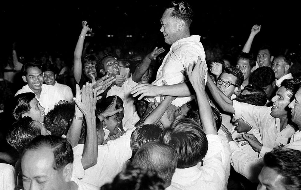 FILE - In this Sept. 21, 1963, file photo, Singapore's then-Prime Minister Lee Kuan Yew is hoisted by supporters after leading his People's Action Party to a landslide victory in the elections in Singapore. 