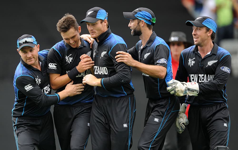 New Zealand’s Trent Boult, second left, is congratulated by teammates after dismissing South African batsman Quinton De Kock during their Cricket World Cup semifinal in Auckland, New Zealand.