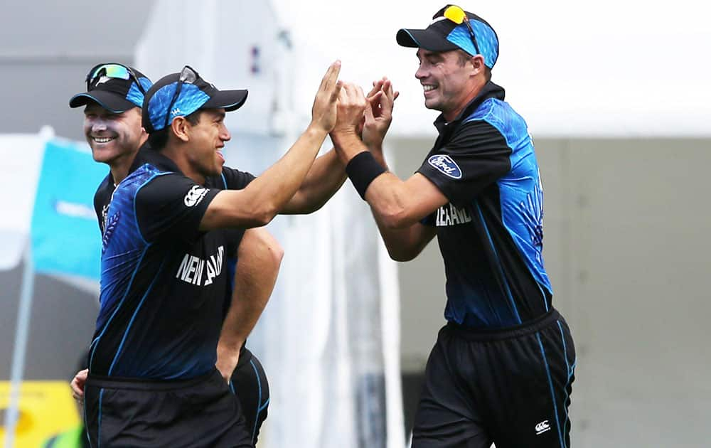 New Zealand’s Tim Southee, right, is congratulated by teammate Ross Taylor after taking a catch to dismiss South African batsman Quinton De Kock during their Cricket World Cup semifinal in Auckland, New Zealand.