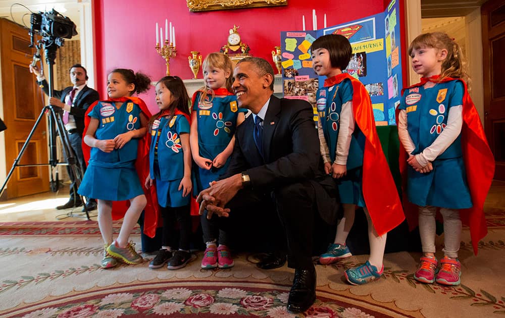 President Barack Obama poses with six-year-old Girl Scouts from Tulsa, Okla. during the White House Science Fair, in the Red Room of the White House in Washington.