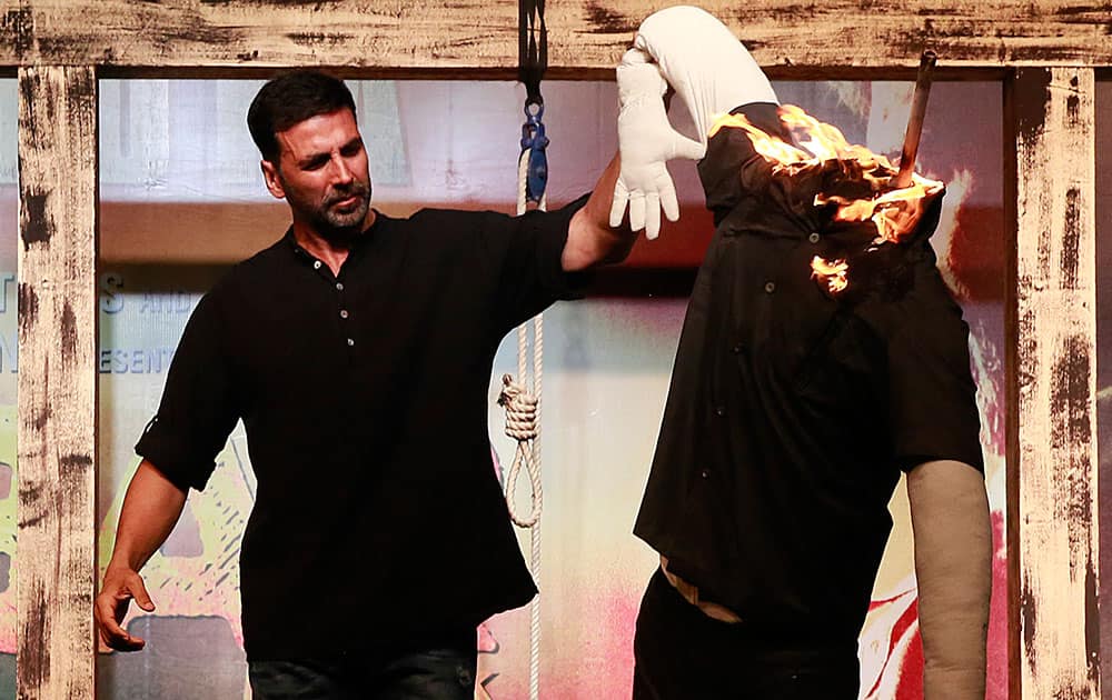 Bollywood actor Akshay Kumar burns an effigy representing corruption during the trailer launch of his upcoming movie Gabbar in Mumbai.