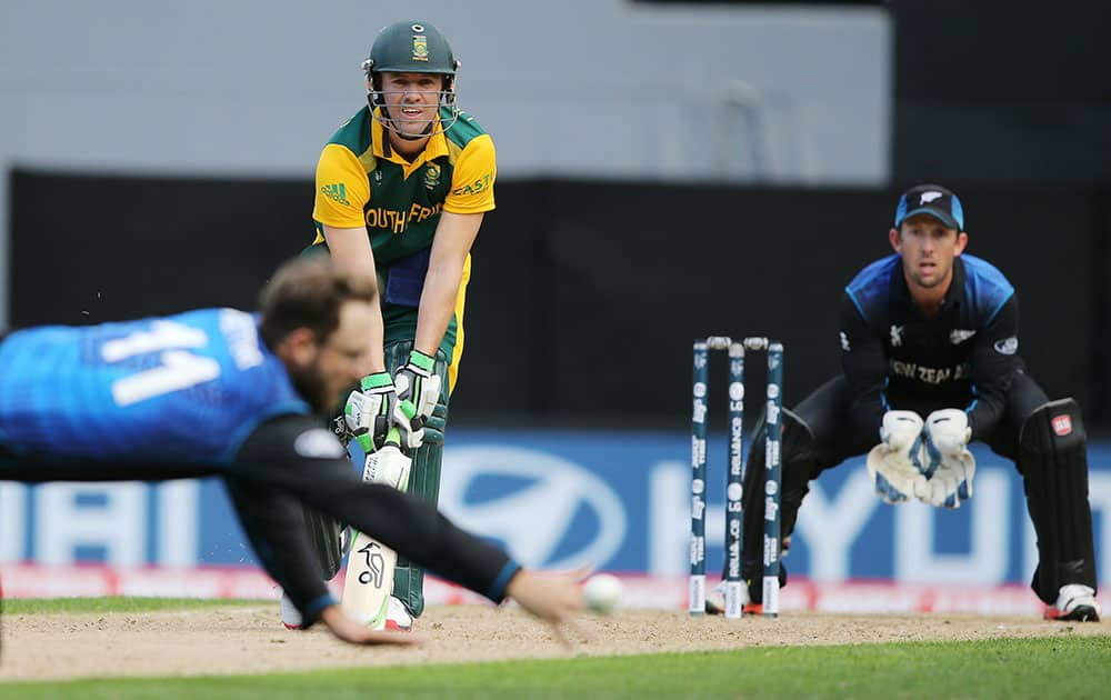 South Africa's AB de Villiers plays a shot as New Zealand bowler Dan Vettori dives a across to field the ball while wicketkeeper Luke Ronchi watches, right, during their Cricket World Cup semifinal in Auckland, New Zealand.