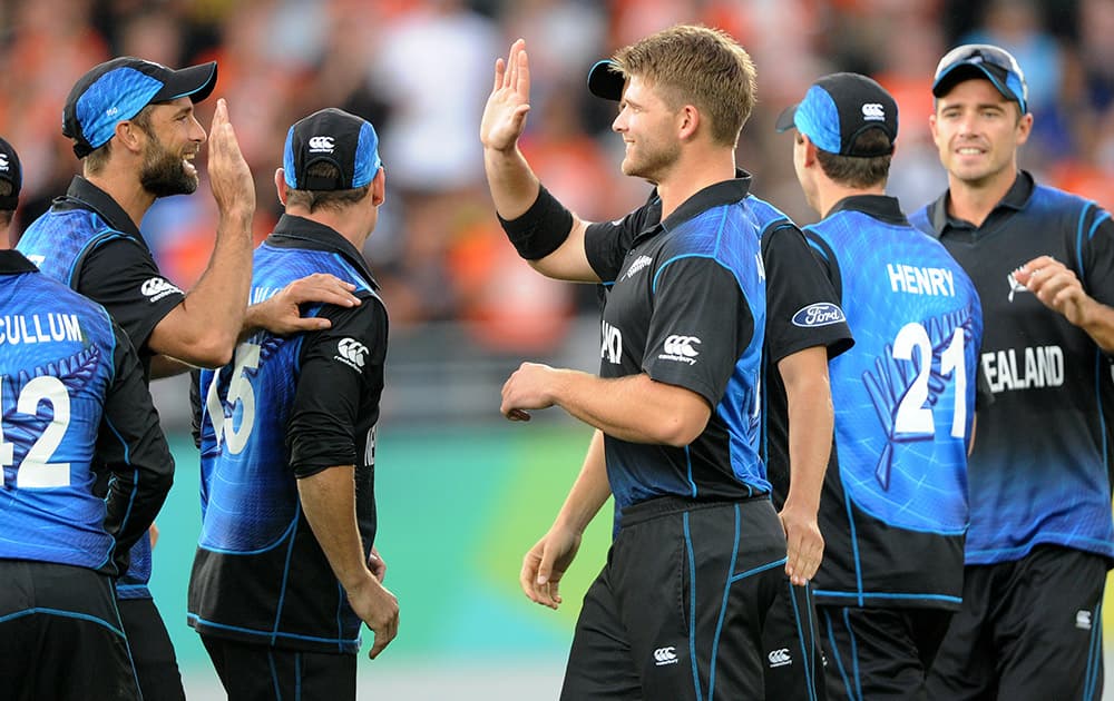 New Zealand’s Kane Williamson centre, is congratulated by teammates after dismissing South Africa's Francois Du Plessis for 82 runs during their Cricket World Cup semifinal in Auckland.