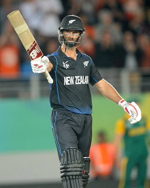 New Zealand’s Grant Elliott waves his bat after scoring 50 runs while batting against South Africa during their Cricket World Cup semifinal in Auckland.