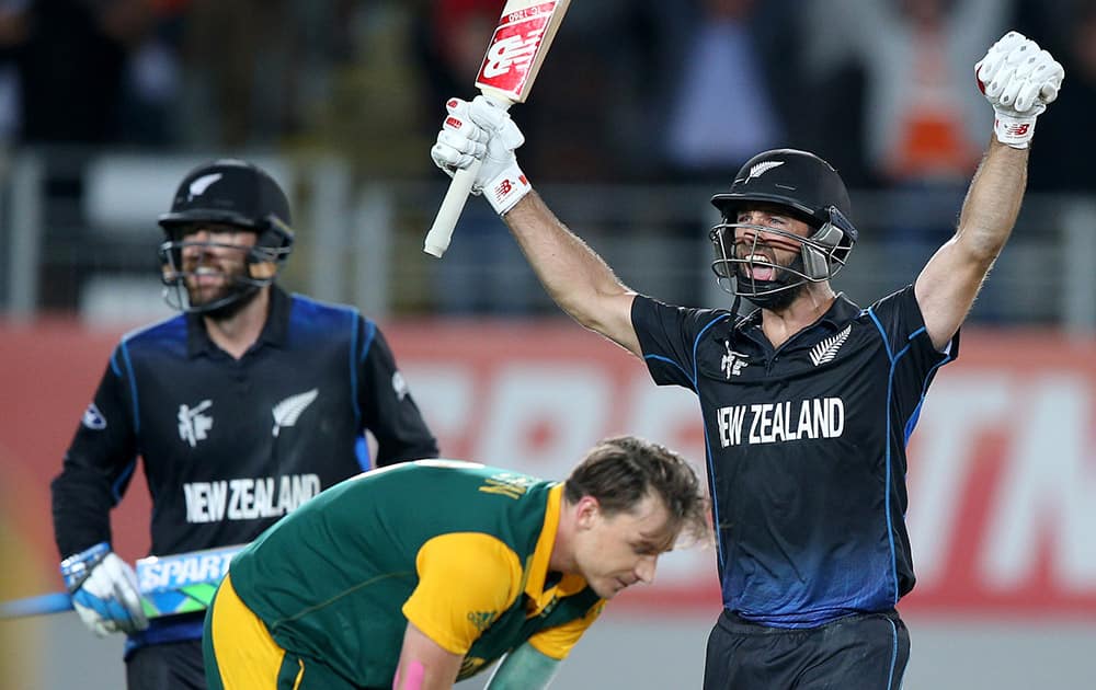 New Zealand’s Grant Elliott raises his arms in celebration with teammate Dan Vettori,as South Africa's Dale Steyn reacts after they defeated South Africa by four wickets in their Cricket World Cup semifinal in Auckland.