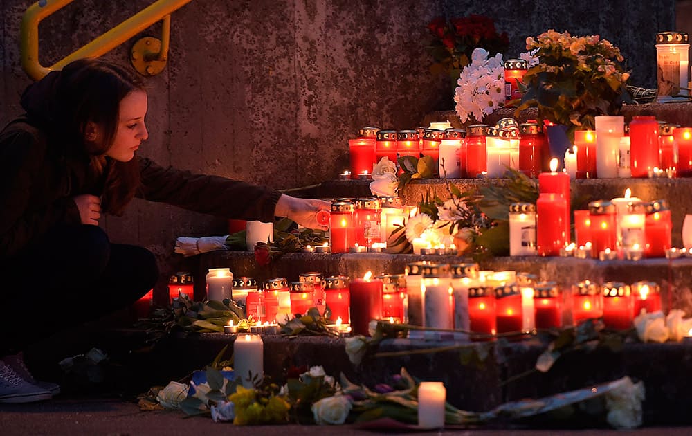 A student lights a candle in front of the Joseph-Koenig Gymnasium in Haltern, western Germany.