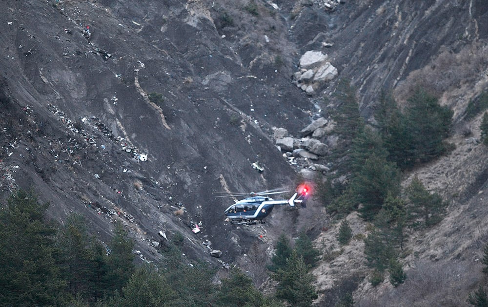 A rescue helicopter flies over debris of the Germanwings passenger jet, scattered on the mountainside, near Seyne les Alpes, French Alps.