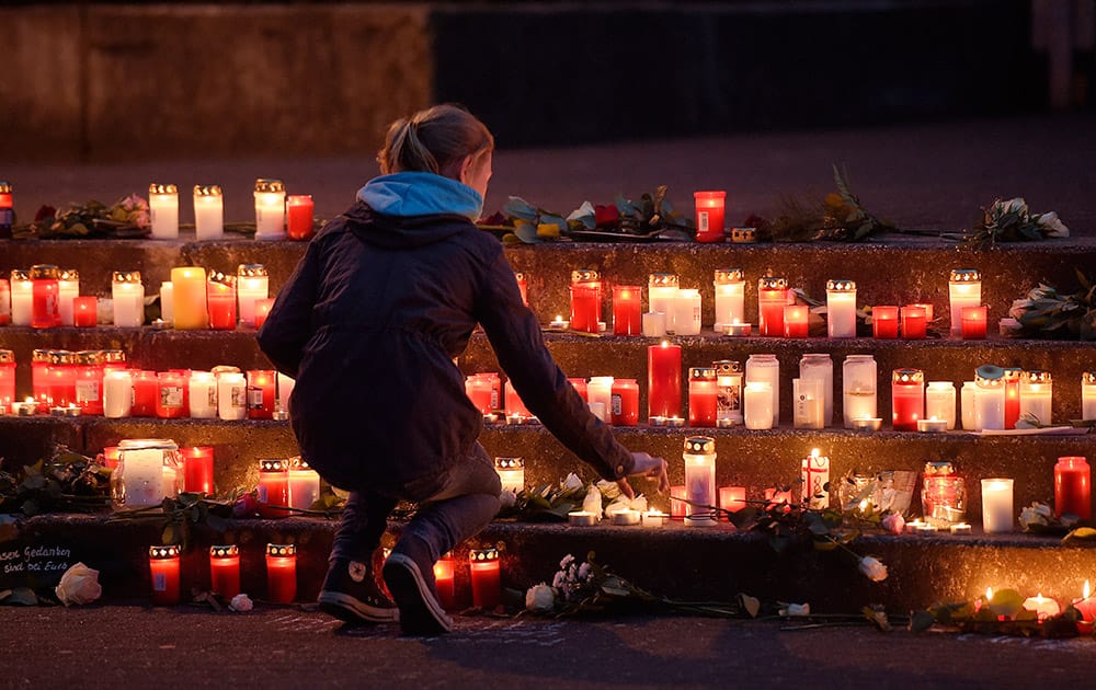 A school girl lights a candle in front of the Joseph-Koenig Gymnasium in Haltern, western Germany.