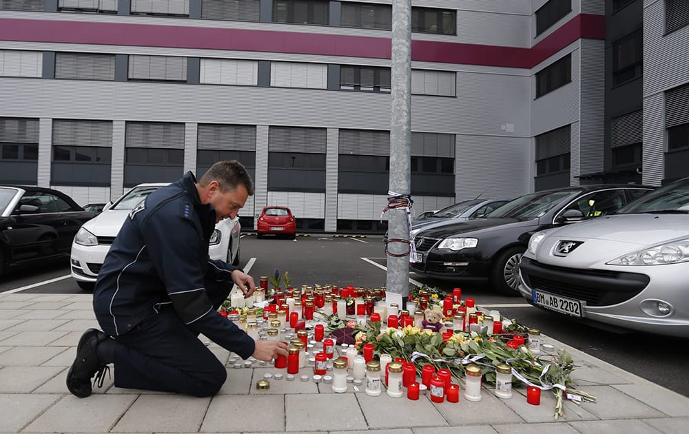 A police officer places a candle in front of the Germanwings headquarters in Cologne