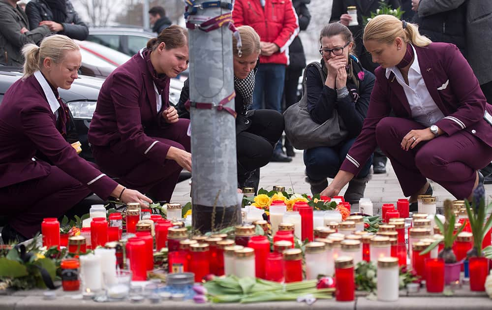 Employees of Germanwings place candles and flowers as they mourn in front of the company's headquarters in Cologne, the day after a Germanwings aircraft , carrying 150 people, crashed in France on the way from Barcelona, Spain, to Duesseldorf, Germany.