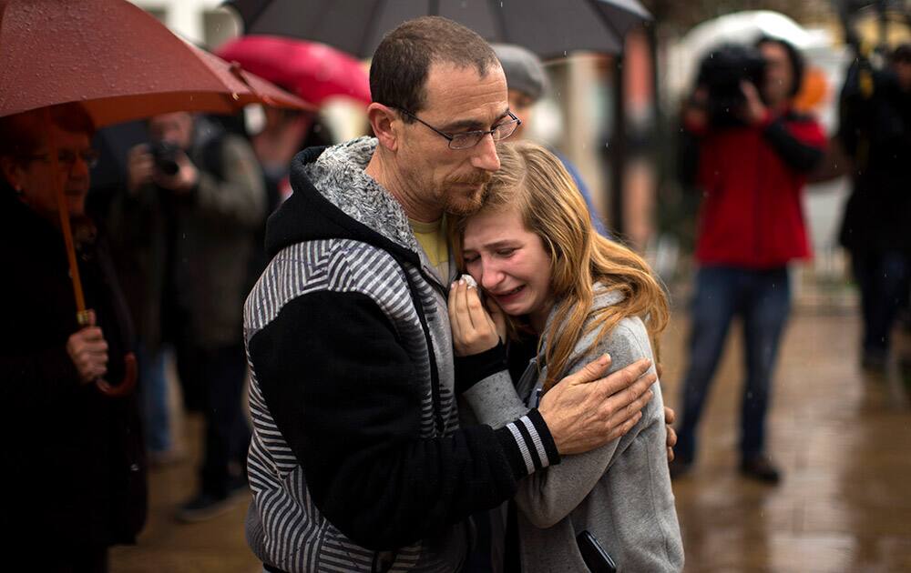 A student who knew some of the German students involved in a crashed plane, reacts during a minute of silence in front of the council building in Llinars del Valles, near Barcelona, Spain.