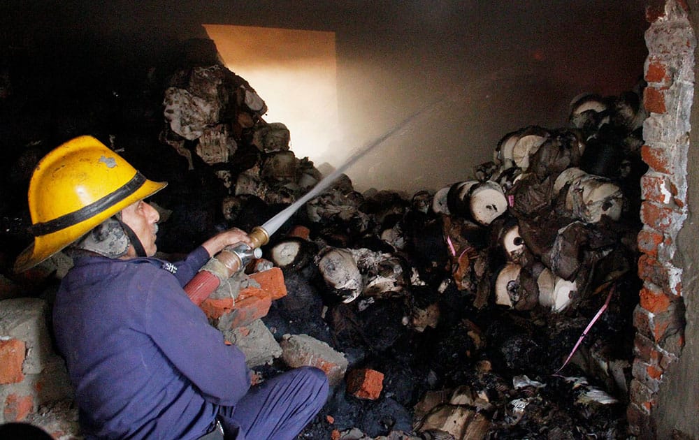 A fireman tries to douse a fire that broke out in a mill in Ahmedabad.