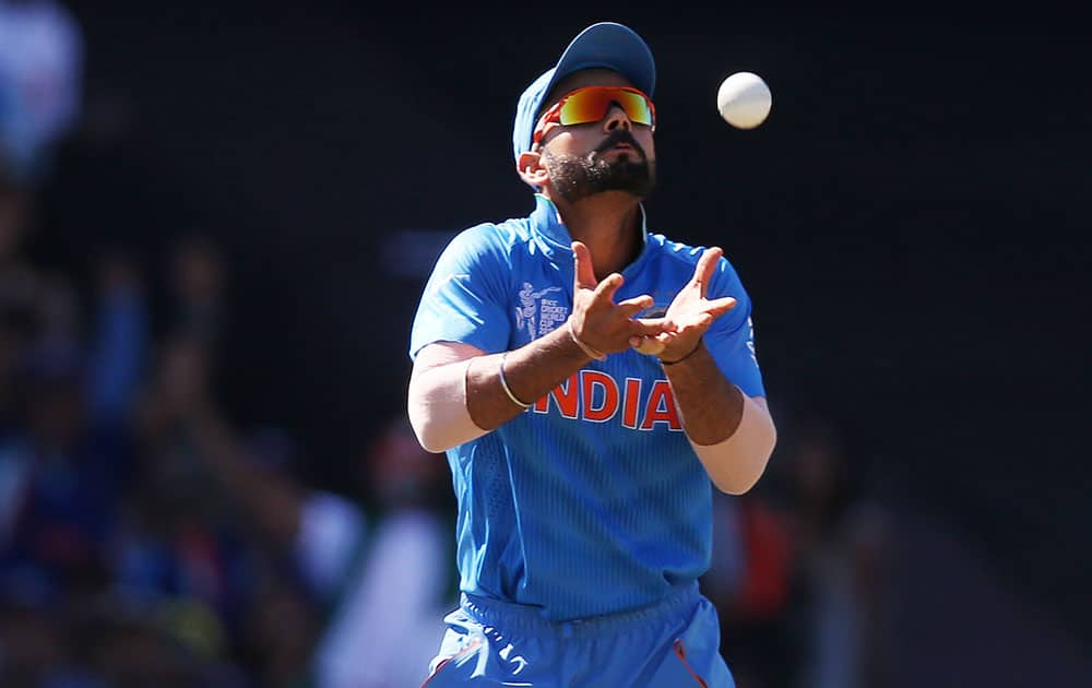 India's Virat Kohli takes a catch to dismiss Australia's David Warner during their Cricket World Cup semifinal in Sydney, Australia.