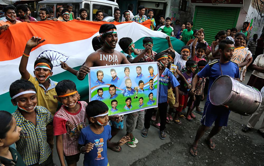 Boys hold a giant national flag and walk in a procession in support of the Indian cricket team ahead of the ICC Cricket World Cup semifinal match against Australia, in Kolkata.