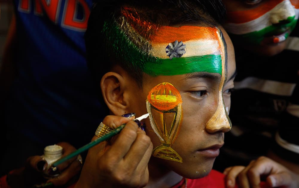 Cricket fan gets his face painted in the colors of the national flag to cheer for the Indian cricket team ahead of the ICC Cricket World Cup semifinal match against Australia, in Ahmedabad,