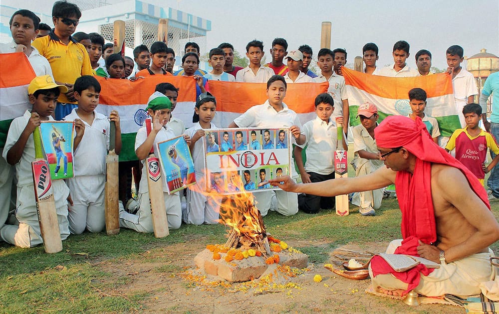 Young cricket fans perform yajna for the Indian Cricket teams victory ahead of their Semi final clash with Australia of ICC Cricket World Cup-2015, at Balurghat in South Dinajpur district of West Bengal.