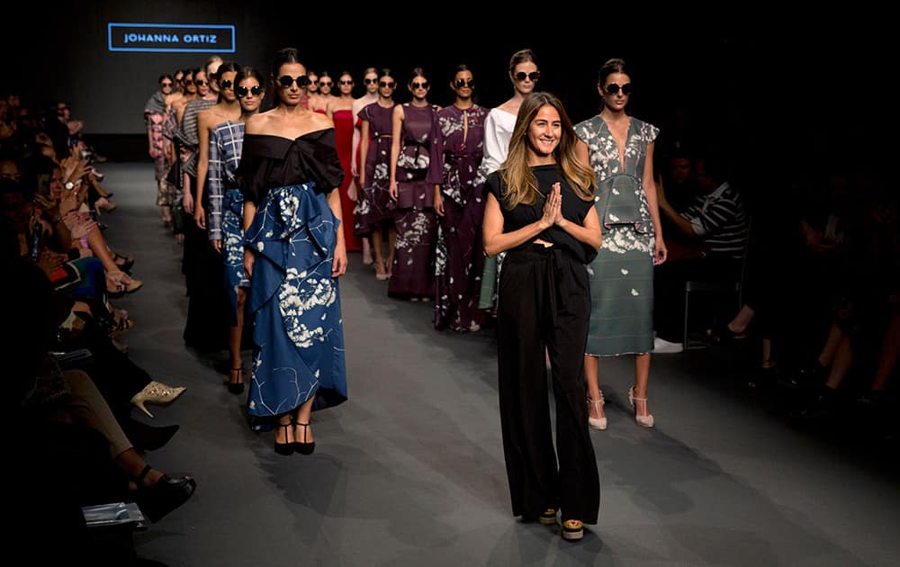 Colombia's fashion designer Johanna Ortiz, center, ackowledges the audience ahead of models wearing creations from her autumn/winter collection during Fashion Week in Lima, Peru.