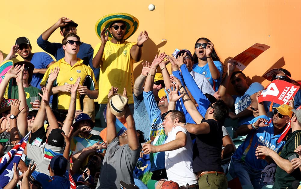 Spectators attempt to catch a ball hit by Australia's Glenn Maxwell during their Cricket World Cup semifinal against India in Sydney, Australia.