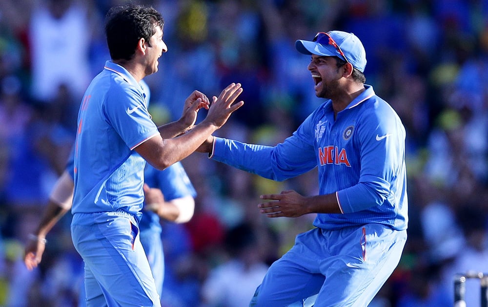 Mohit Sharma, is congratulated by teammate Suresh Raina after taking the wicket of Australia's Michael Clarke during their Cricket World Cup semifinal in Sydney, Australia.