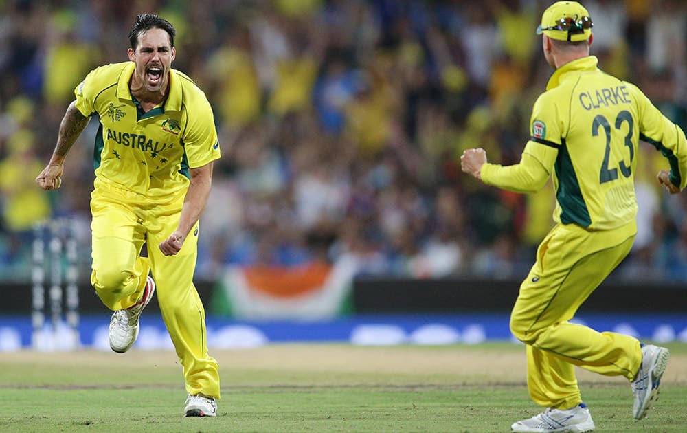 Australia's Mitchell Johnson celebrates with his captain Michael Clarke after taking the wicket of India's Virat Kohli during their Cricket World Cup semifinal in Sydney, Australia.