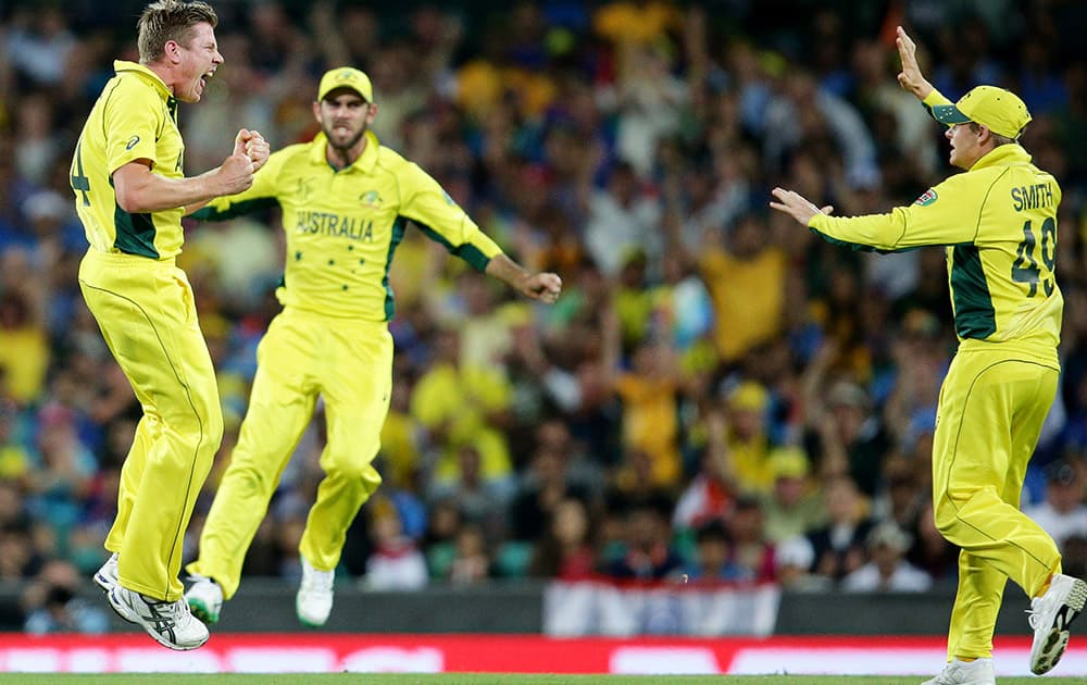 Australia's James Faulkner celebrates with teammates Australia's Steve Smith and Glenn Maxwell after taking the wicket of India's Suresh Raina during their Cricket World Cup semifinal in Sydney, Australia.