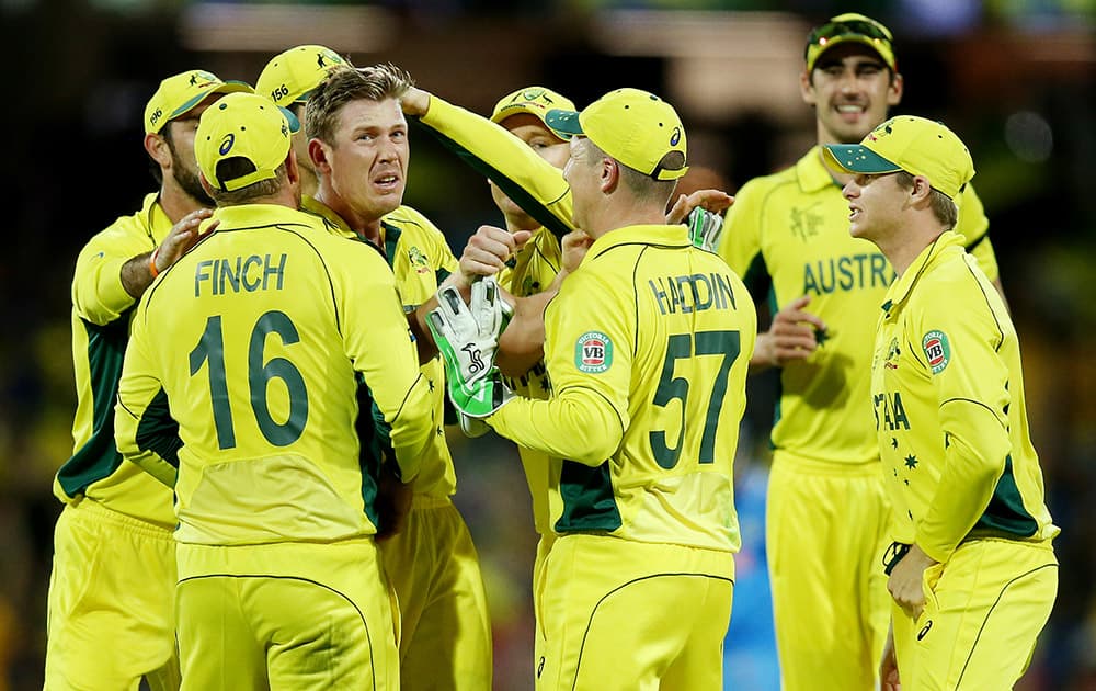 Australia's James Faulkner celebrates with teammates after taking the wicket of India's Suresh Raina during their Cricket World Cup semifinal in Sydney, Australia.