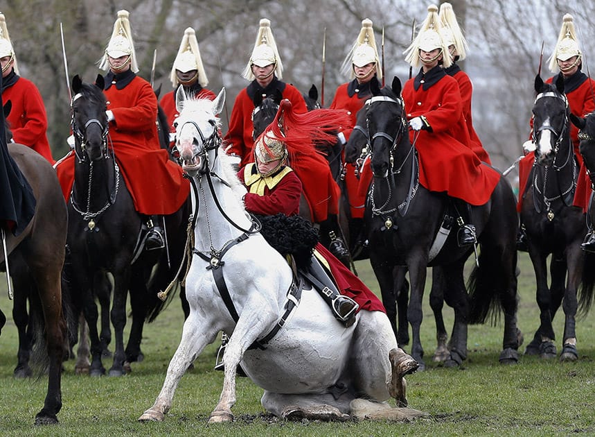 A trumpeter falls off his horse as the Household Cavalry Mounted Regiment parades in Hyde Park in London.