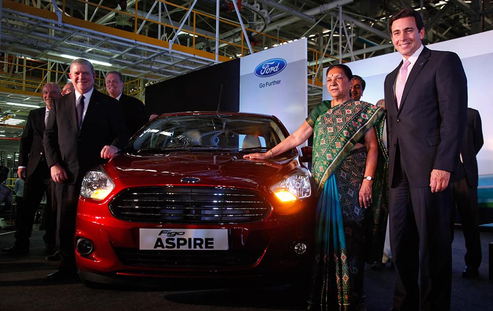 Gujarat state chief minister Anandiben Patel and Ford President and CEO Mark Fields, right, pose for photographs standing beside a Ford Figo Aspire during the inauguration of Ford's manufacturing facility and engine plant at Sanand, near Ahmedabad.