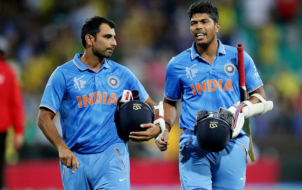 Umesh Yadav and Mohammed Shami walk from the field after their 95 run loss to Australia in their Cricket World Cup semifinal in Sydney, Australia.