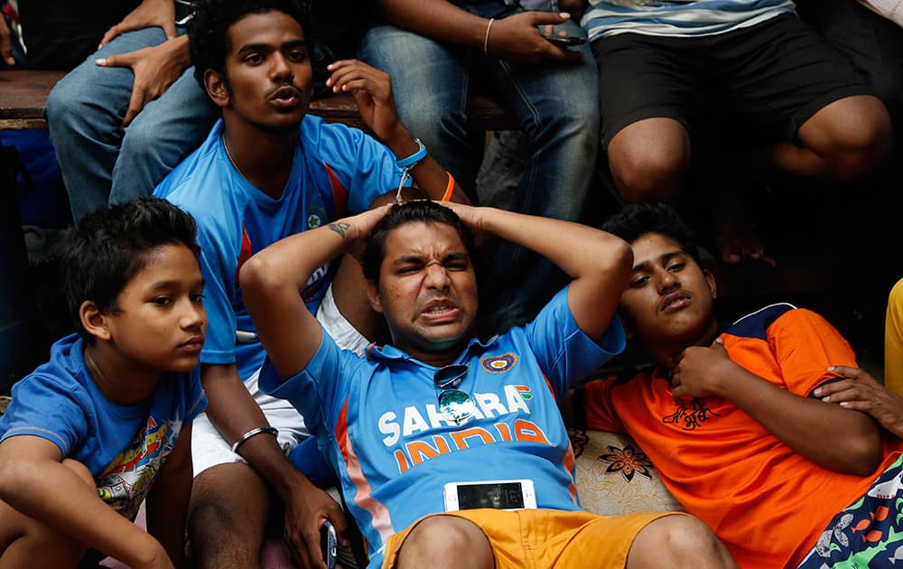 Cricket fans react as they watch on television the ICC Cricket World Cup semifinal match between India and Australia in Mumbai.