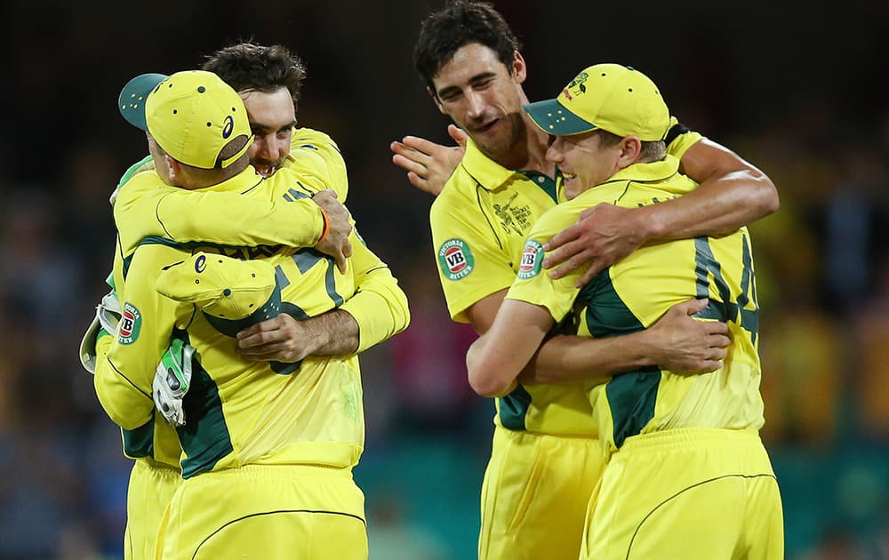 Australian players embrace as they celebrate after defeating India by 95 runs in their Cricket World Cup semifinal in Sydney, Australia.