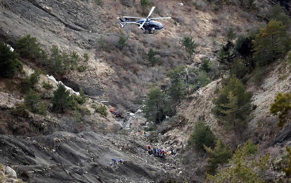 A helicopter flies overhead as rescue workers work at the crash site of Germanwings passenger plane near Seyne-les-Alpes, France.