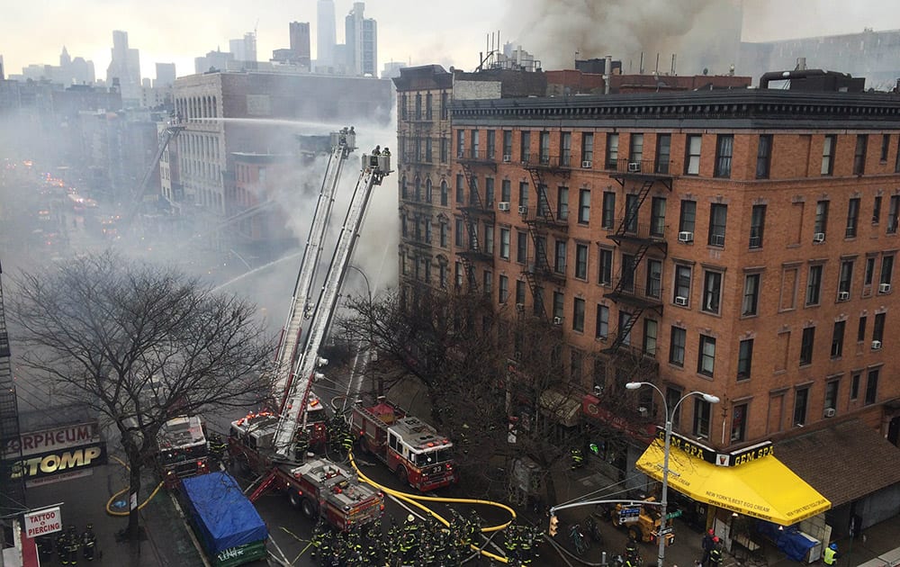 Smoke billows from a building in New York's East Village neighborhood at the scene of a large fire and a partial building collapse.