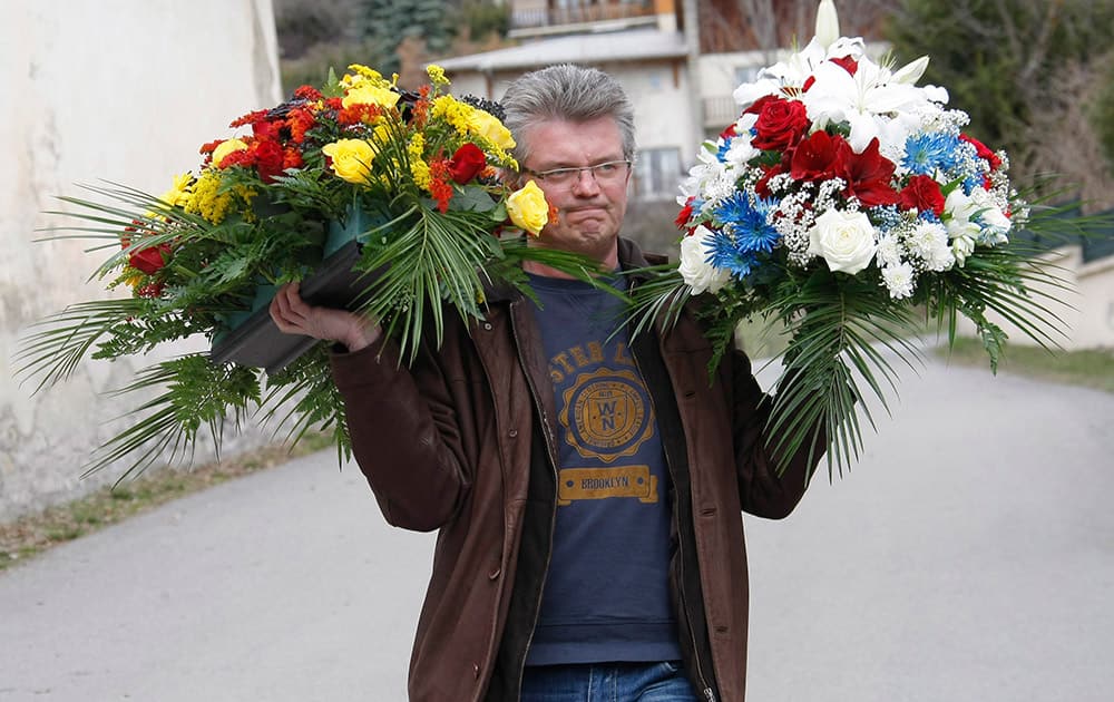 A man carries flowers prior to an official ceremony for the victims of the Germanwings plane crash in Seyne-les-Alpes, France.