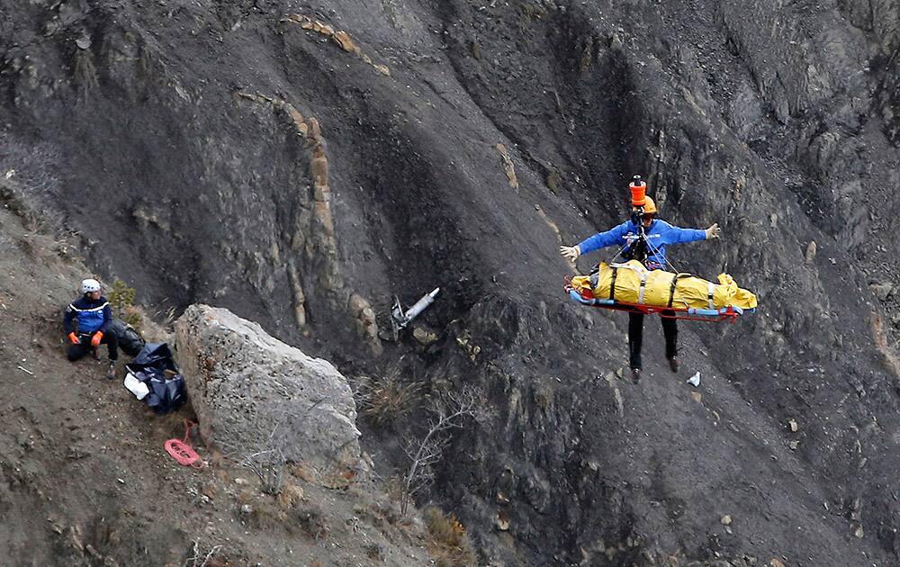 A rescue worker is lifted into an helicopter at the crash site near Seyne-les-Alpes, France.