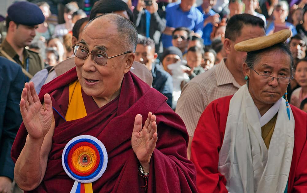 Tibetan spiritual leader the Dalai Lama, greets devotees on his arrival at the Tibetan Institute of Performing Arts in Dharmsala.