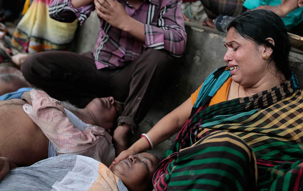 A Bangladeshi Hindu devotee Sapna Das cries as she holds the body of a relative who was killed in a stampede in Langalbandh, 20 kilometers (12 miles) southeast of capital Dhaka, Bangladesh.