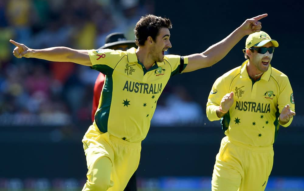 Australia's Mitchell Starc, left, celebrates with teammate Glenn Maxwell after taking the wicket of New Zealand captain Brendon McCullum for no score during the Cricket World Cup final in Melbourne, Australia.