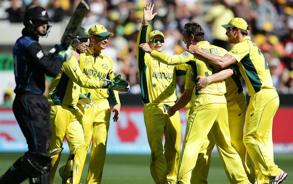 Australian players celebrate after taking the wicket of New Zealand’s Martin Guptill, left, during the Cricket World Cup final in Melbourne, Australia.