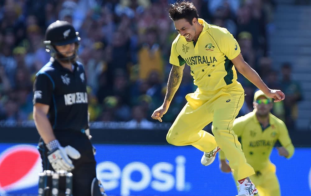 Australia's Mitchell Johnson, right, celebrates after taking the wicket of New Zealand’s Kane Williamson, left, during the Cricket World Cup final in Melbourne, Australia.