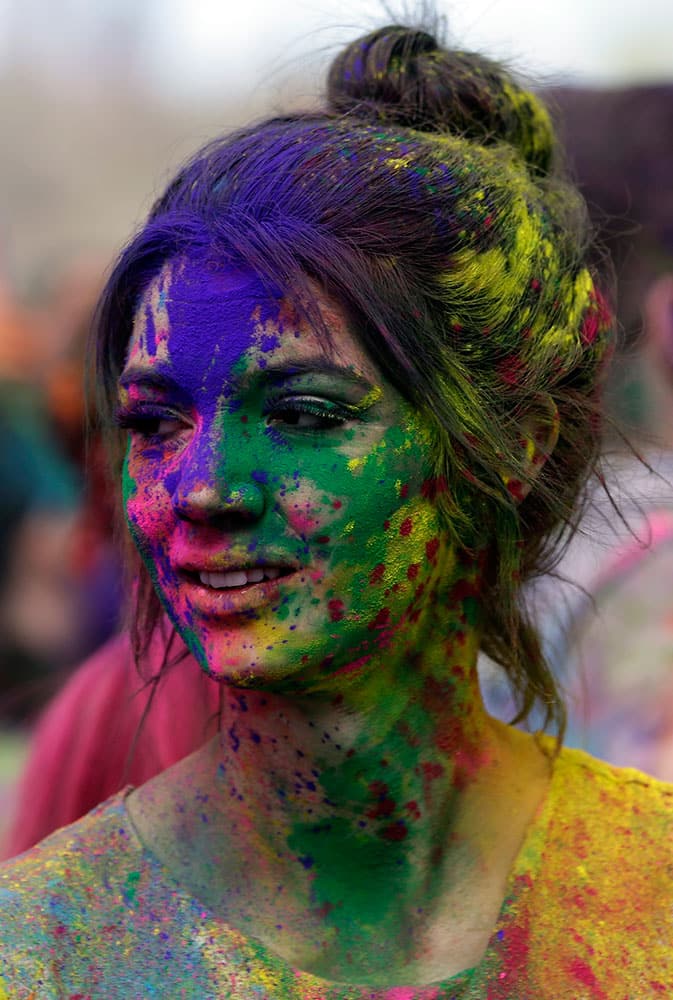 A reveler covered in colored corn starched looks on during the 2015 Festival of Colors, Holi Celebration at the Krishna Temple, in Spanish Fork, Utah.