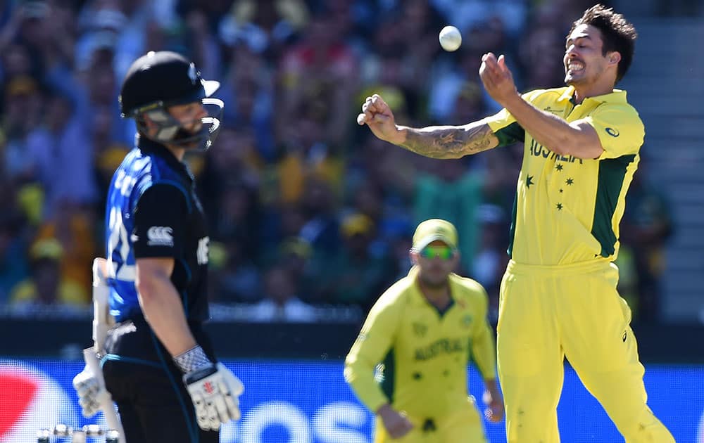 Australia's Mitchell Johnson, right, celebrates after taking the wicket of New Zealand’s Kane Williamson, left, during the Cricket World Cup final in Melbourne, Australia.