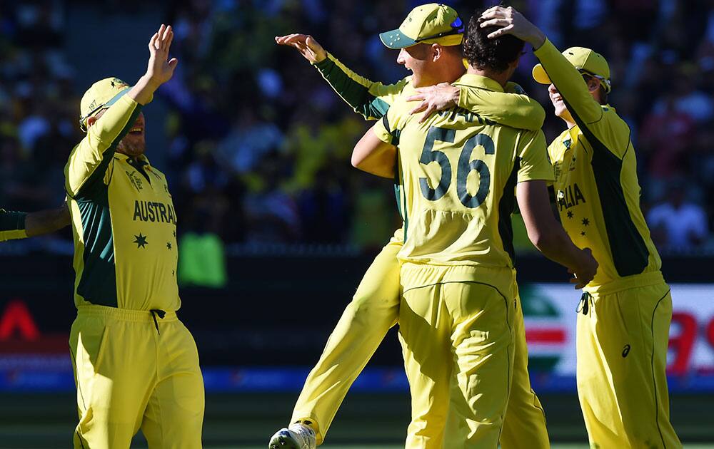 Australian players congratulate teammate Mitchell Starc, 56, after taking the wicket of New Zealand wicketkeeper Luke Ronchi for no score during the Cricket World Cup final in Melbourne, Australia.