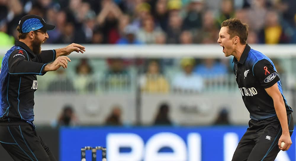 New Zealand’s Dan Vettori, left, moves to congratulate teammate Trent Boult for the dismissal of Australia's Aaron Finch during the ICC Cricket World Cup final in Melbourne, Australia