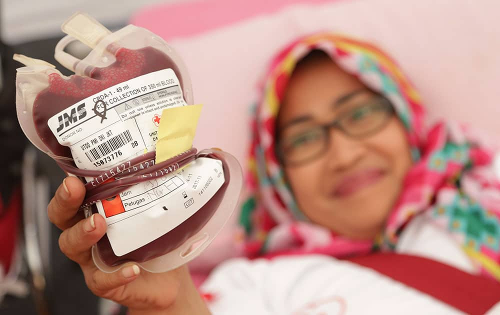 A women hold her donated blood in Jakarta, Indonesia. Blood donation activities are undertaken by Indonesian Red Cross to help overcome the shortage of blood.