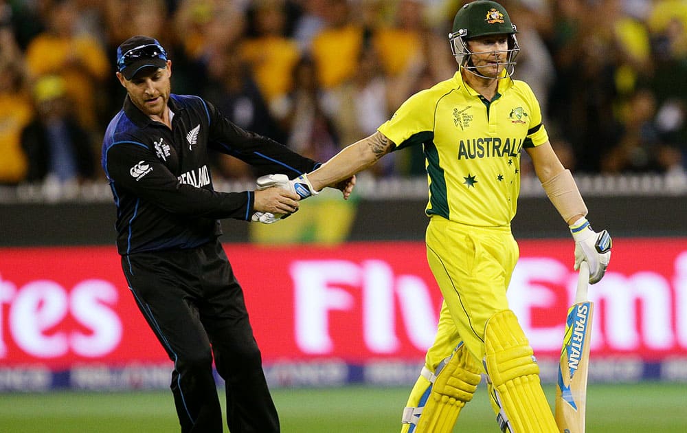 New Zealand captain Brendon McCullum, left, congratulates Australian captain Michael Clarke as he leaves the field after he was dismissed for 74 runs during the Cricket World Cup final in Melbourne, Australia.