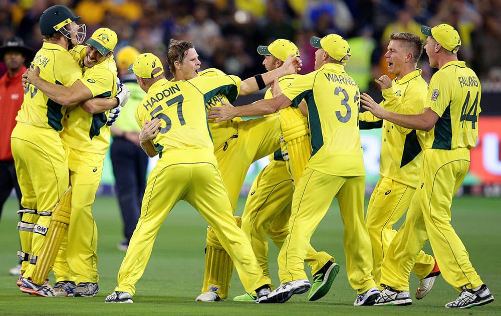 Australian players celebrate after they defeated New Zealand by seven wickets to win the Cricket World Cup final in Melbourne, Australia.