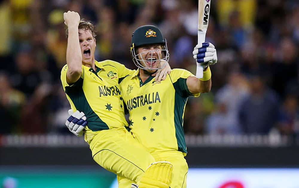 Australia's Steve Smith, left, and teammate Shane Watson celebrate after defeating New Zealand by seven wickets to win the Cricket World Cup final in Melbourne, Australia.