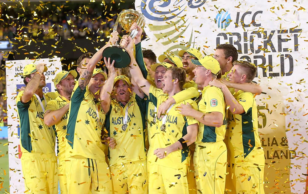 Australian captain Michael Clarke holds the trophy aloft with his teammates as they celebrate their seven wicket win over New Zealand in the Cricket World Cup final in Melbourne, Australia.